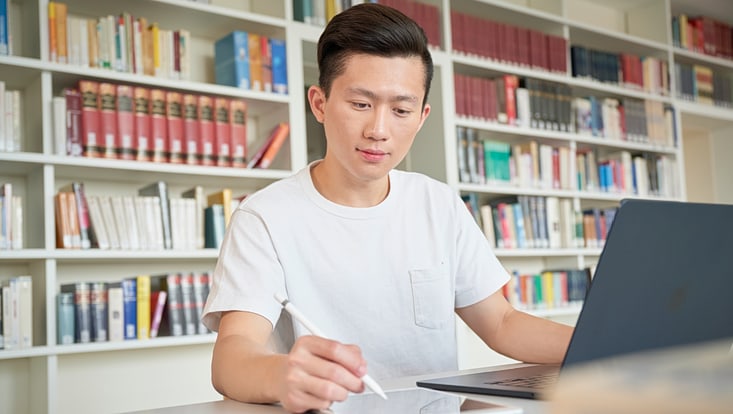 Student lernend in Bibliothek