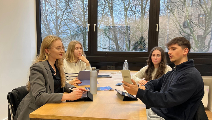 spencer student risk management challenge team der business school Studierende sitzen an einem Tisch