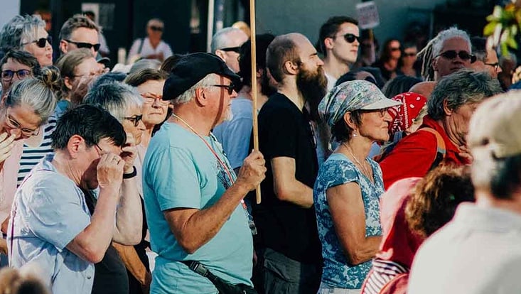 Menschenmenge auf einer Kundgebung mit Schildern und Protest