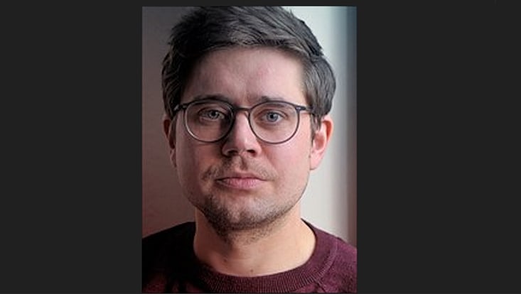 Männliche Person mit kurzen Haaren und dunkler Brille