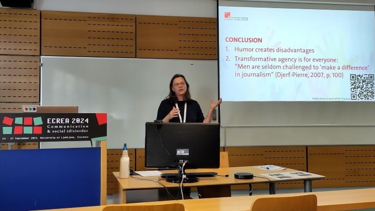 Juliane Lischka hält stehend einen Vortag. Im Hintergrund ist die Slide mit zwei Conclusions zu sehen.