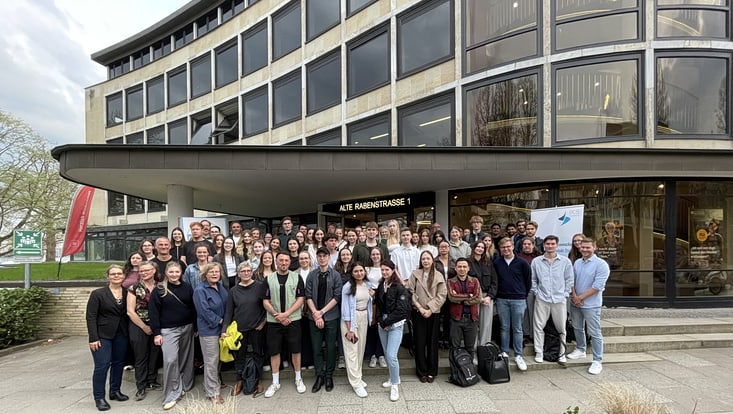 Gruppe junger Menschen vor Gebäudeeingang