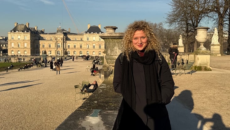 Julia Diana Lenk in Paris vor historischem Gebäude im Park