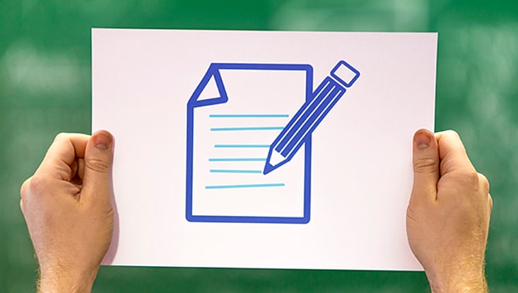 Two hands hold a4 white paper with notebook and pen