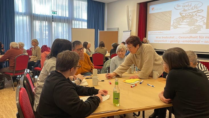 Einige Menschen arbeiten gemeinsam um einen Tisch herum.