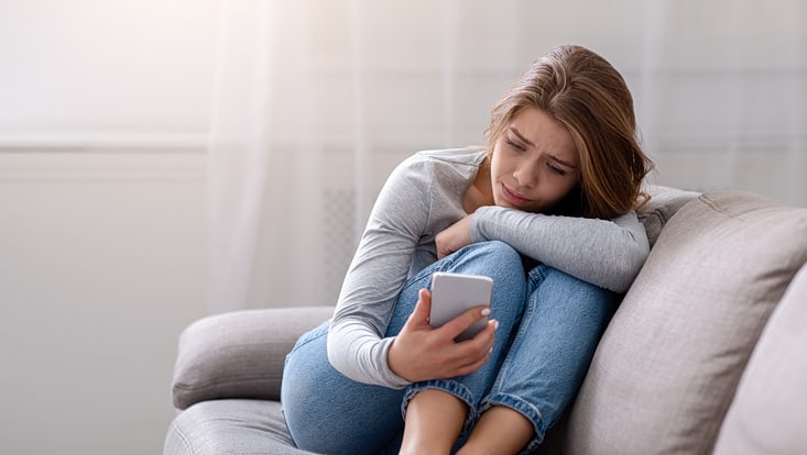Einsam aussehende Frau am Handy