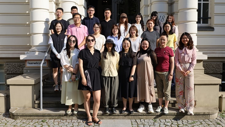 Chinesinnen und Chinesen auf Treppe vor historischem Portal