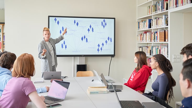 Seminarsituation mit mehreren Menschen und einer Referentin