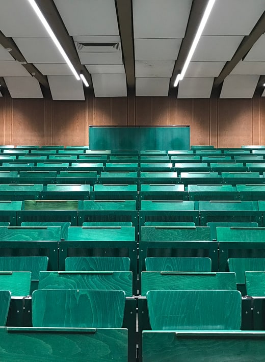 Leerer Hörsaal mit dunkel grünen Stühlen