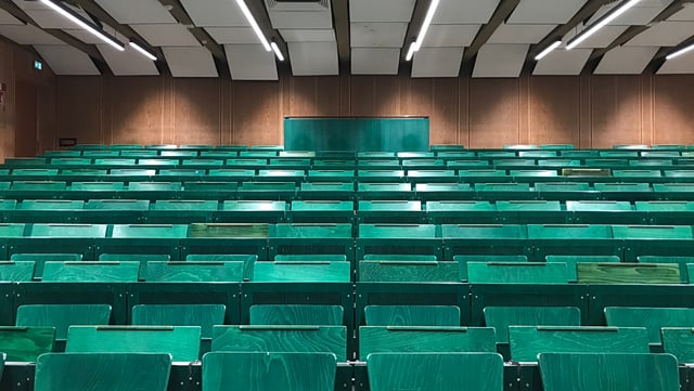 Leerer Hörsaal mit dunkel grünen Stühlen