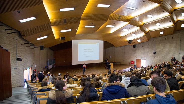20180220-universitätstag-2018-michel-dingler-23-733x414 Menschen sitzen im Hörsaal