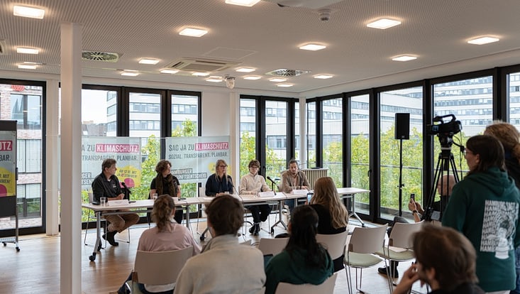 Saal der Pressekonferenz mit fünf Personen auf dem Podium.