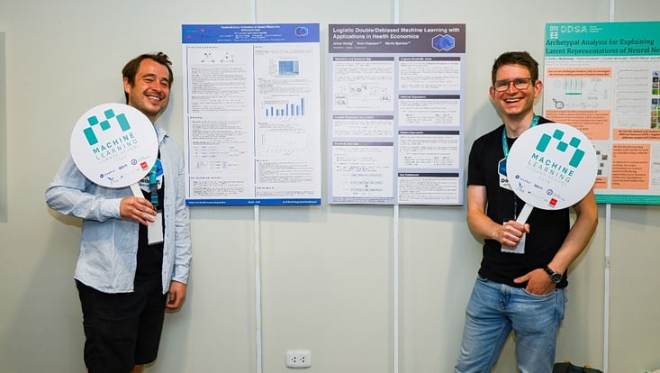 two men in front of posters