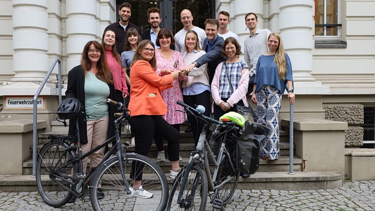 Group of people on stairs with two bicycles