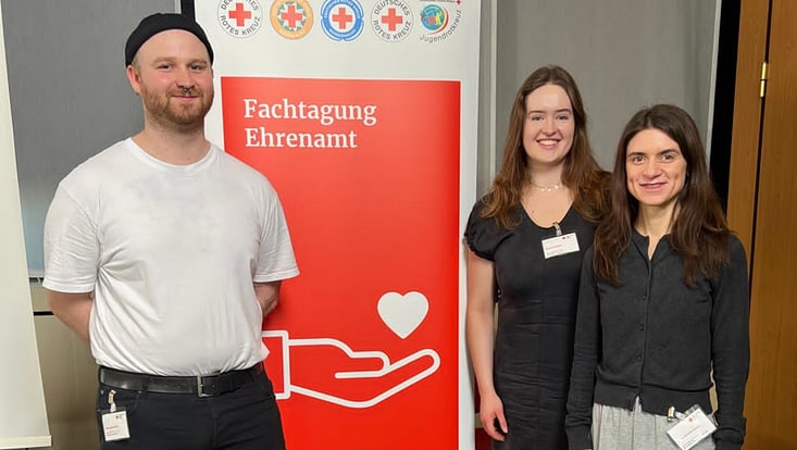 Drei Leute vor Stele