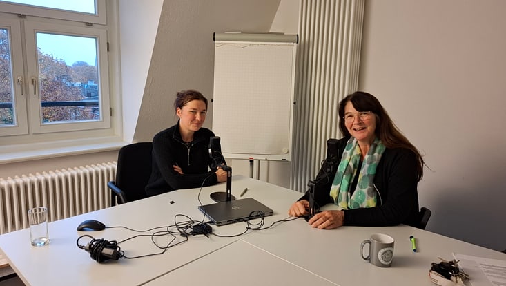 zwei Frauen am Tisch mit Mikrofonen