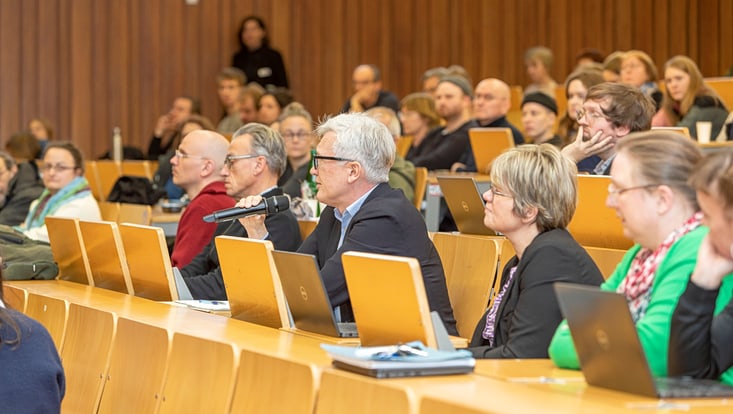Person aus Publikum mit Mikrofon in der Hand