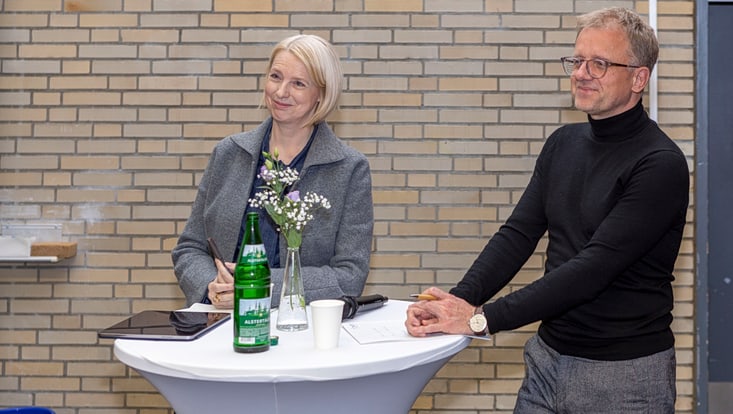 Männliche und weibliche Person an Stehtisch