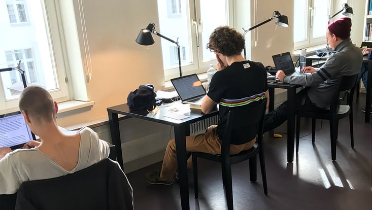 Student sitzt an Tisch in Bibliothek
