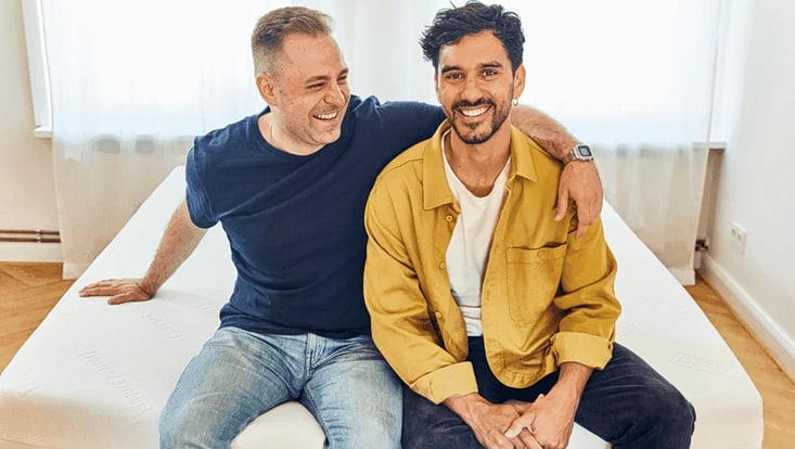 Zwei junge Männer auf Sofa sitzend, lachend