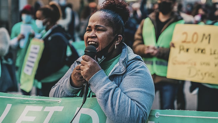 Afroamerikanische Frau spricht in ein Mikrofon bei einer Demonstration