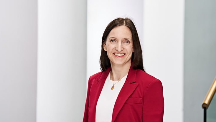 Foto von Johanna Kokot (lange dunkle Haare, roter Blazer)