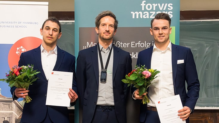 Drei Männer im Anzug vor Roll-up