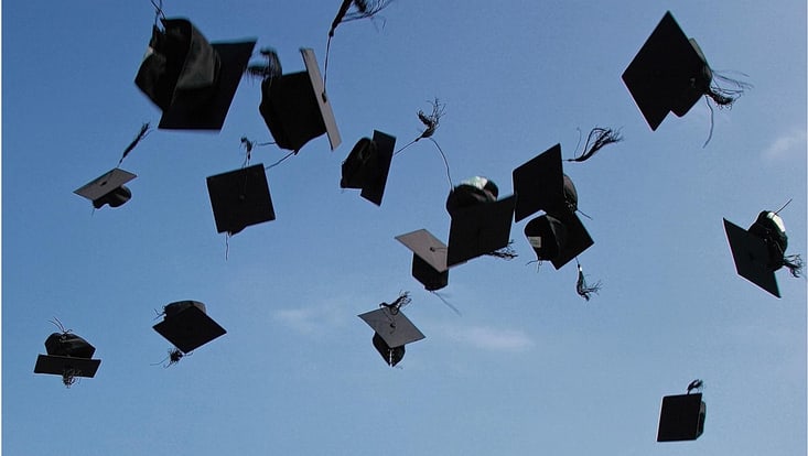 Symbolbild Graduation: Hüte in der Luft