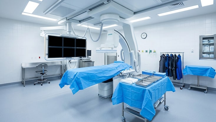 Cardiac Catheterization Lab Empty with Fluoroscopy C-Arm and Sterile Procedure Table in Bright Light