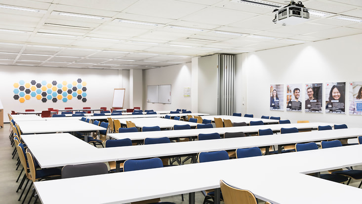 Seminarraum bestuhlt mit Pinwänden und Beamer