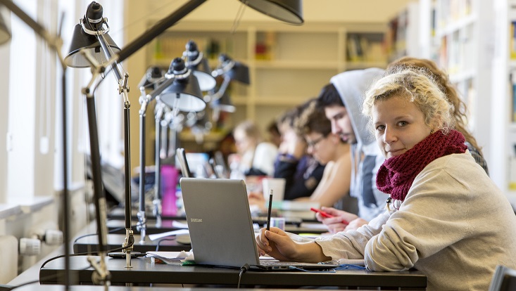Reihe von Einzelarbeitsplätzen mit arbeitenden Menschen/Row of individual workspaces with people working