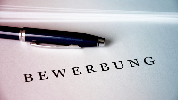 Blatt mit Schriftzug "Bewerbung", daneben ein Kugelschreiber