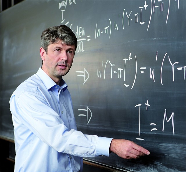 Auf diesem Bild steht Prof. Dr. Mathias Kifmann an einer Tafel und erklärt die Beschriftungen.