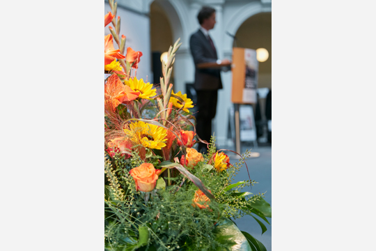 01 Ein Blumengesteck auf der Bühne im Altbau der Staats- und Universitätsbibliothek, im Hintergrund der Direktor der Graduate School Prof. Dr. Timo Busch