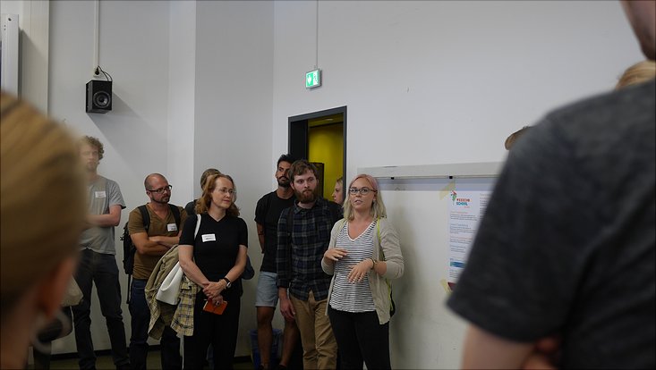 Eine Studierende stellt das Poster für den Kooperationspartner Weekendschool vor