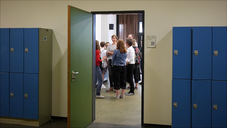 Externe Besucherinnen unterhalten sich über die Poster in den Seminarräumen