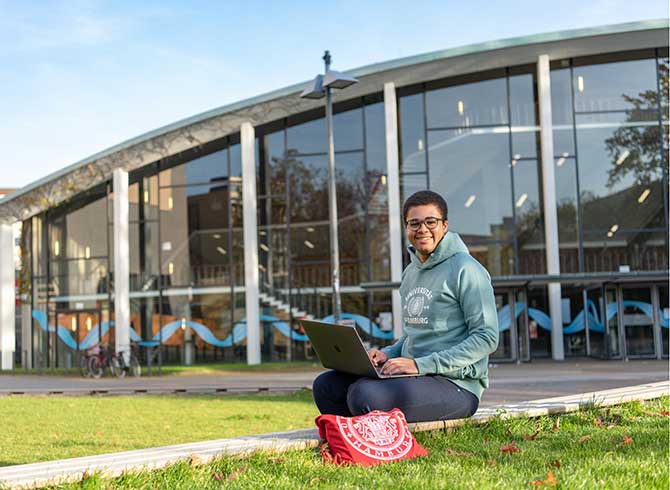audimax-uhh Student mit Laptop vor dem Audimax der Universität Hamburg