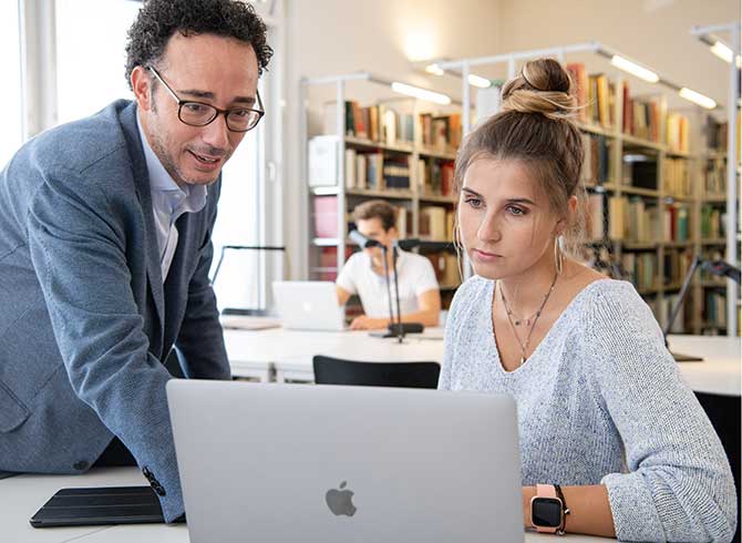 Ein Dozent und eine Studentin vor dem Computer