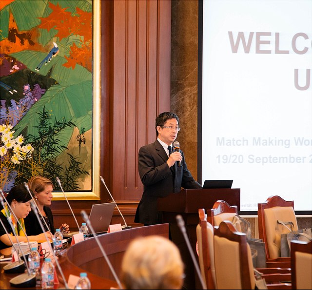 man with microphone speaking in conference room