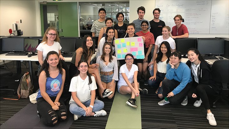 Tracy Cheung group picture of students presenting poster in classroom