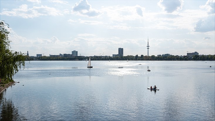 733x414-tan sunny panorama view over Alster lake and tv tower, on the water sailing boats and canoes