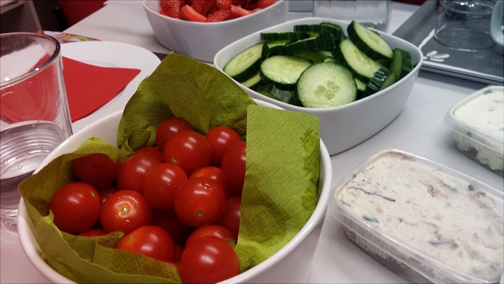 Gedeckter Frühstückstisch mit Tomaten, Gurken und Erdbeeren