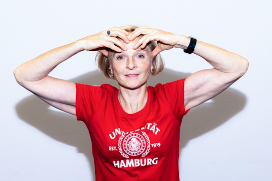 Eye relaxation exercise Smoothing out: A person holds both hands over their eyes with their fingertips touching their forehead.