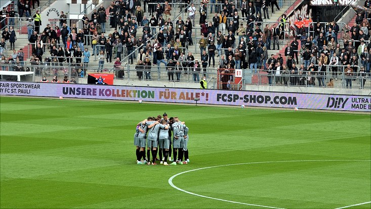 Fußballer umarmen sich im Millerntor-Stadion.