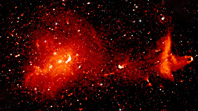 Der Coma-Cluster ist 300 Millionen Lichtjahre von der Erde entfernt und besteht aus mehr als 1.000 Galaxien, die hier im Radio- und Infrarot-Bereich gezeigt sind. Die Radiodaten machen die Strahlung von hochenergetischen Teilchen sichtbar, die den magnetisierten Raum zwischen den Galaxien durchdringen.