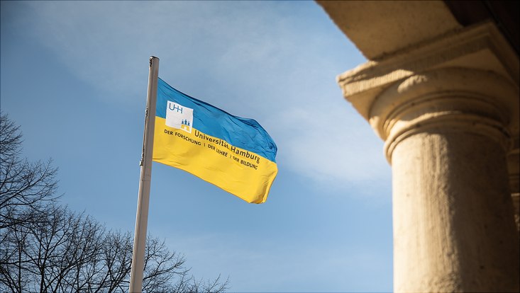 Uniflagge vor dem Hauptgebäude in gelb und blau
