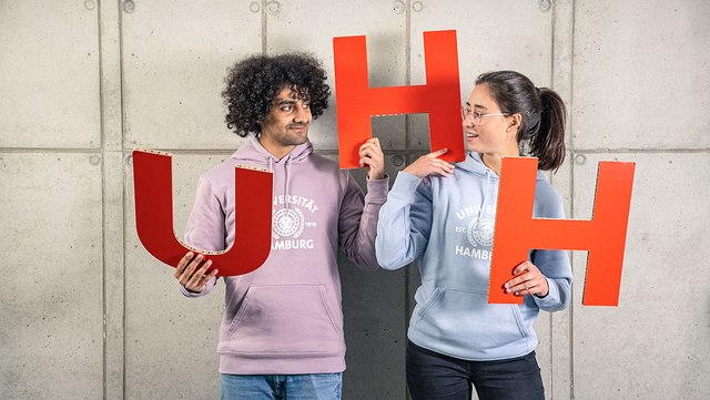 Zwei Studentin halten die großen Buchstaben UHH