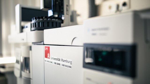 Nahaufnahme eines Massenspektrometers, auf dem das Logo der Universität Hamburg abgebildet ist.