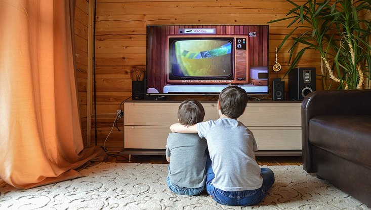 Zwei Kinder schauen auf einer Fernseher