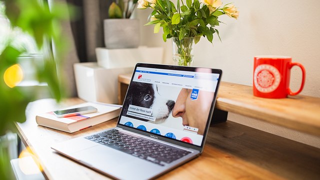 Intern abrufbare Angebote und Informationen Ein Laptop steht auf einem Schreibtisch, geöffnet ist die Homepage der Uni Hamburg.
